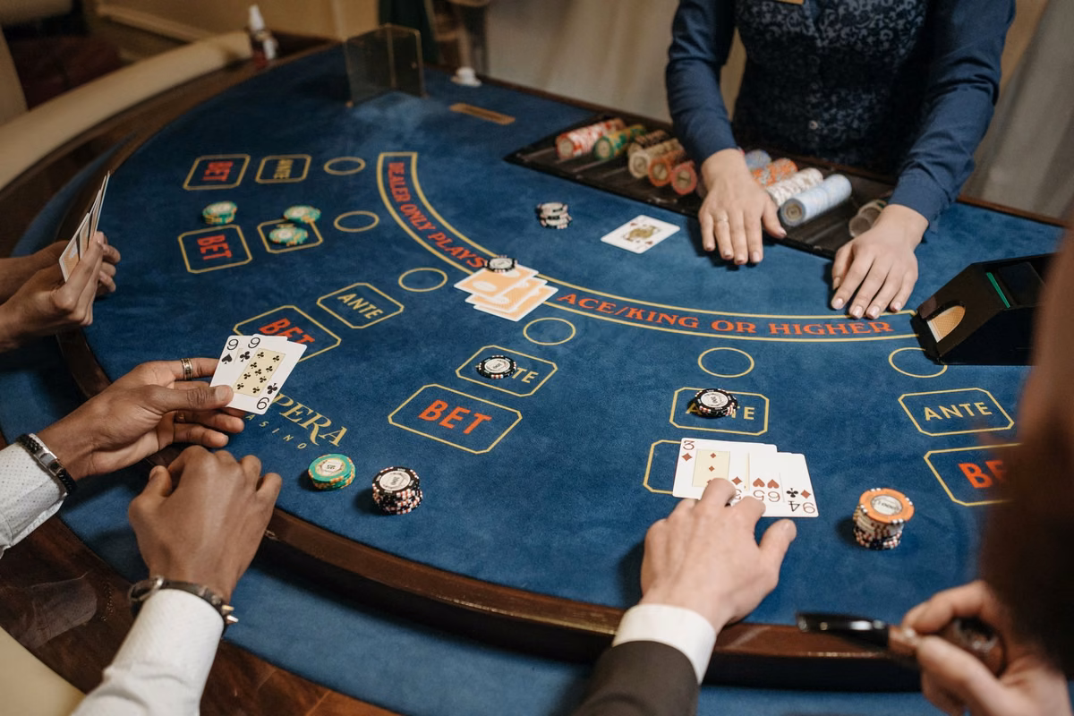Joueurs autour d’une table de poker au tapis bleu, cartes et jetons en main